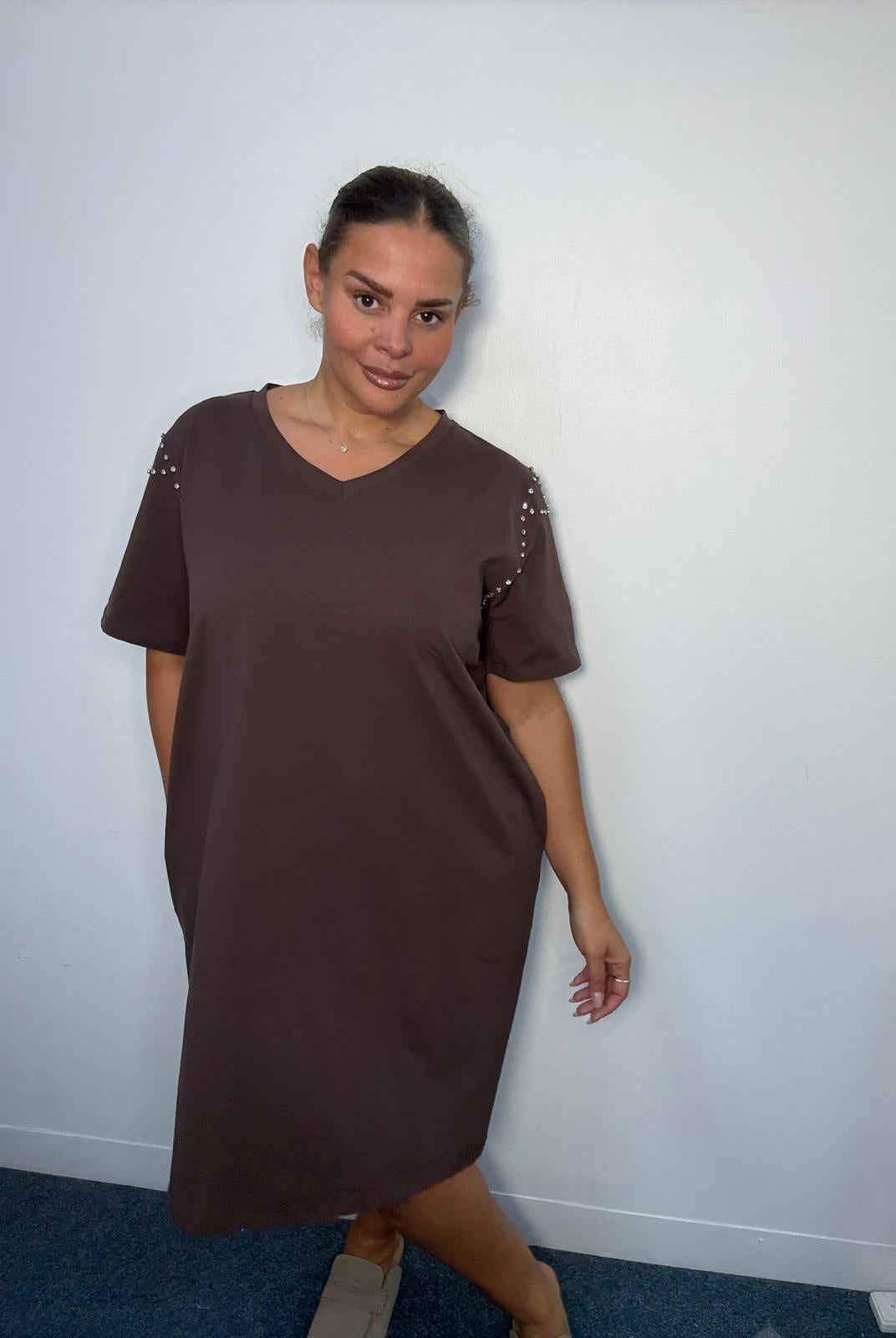 Plus-size model wearing a chocolate brown V-neck midi dress with short sleeves, sparkling shoulder embellishments and relaxed fit.