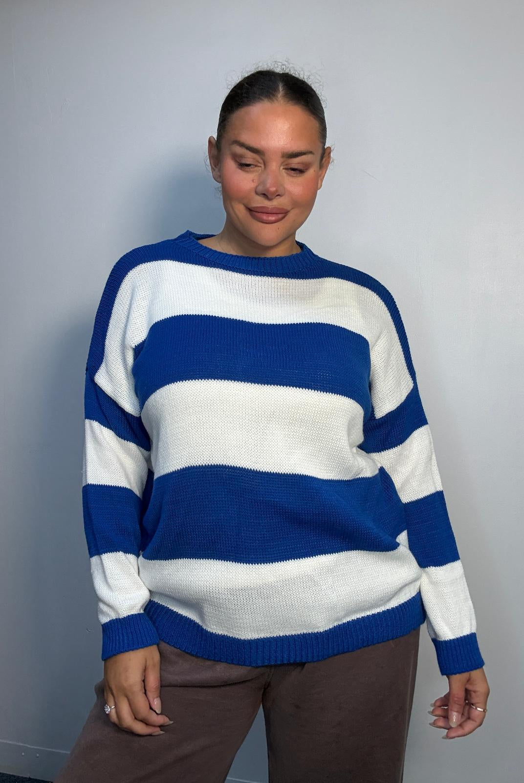 Plus-size model wearing a royal blue and white horizontally striped knitted jumper with round neckline, long sleeves and ribbed trims.