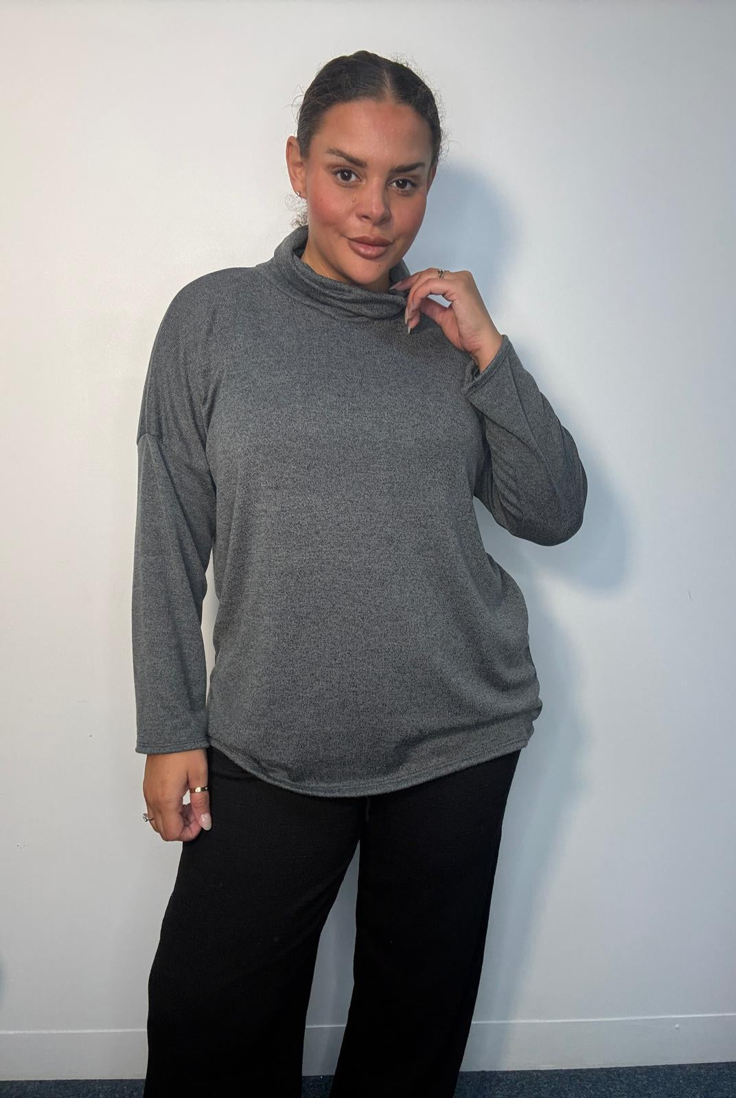 Plus-size model wearing a grey cowl neck long sleeve top with a relaxed fit.