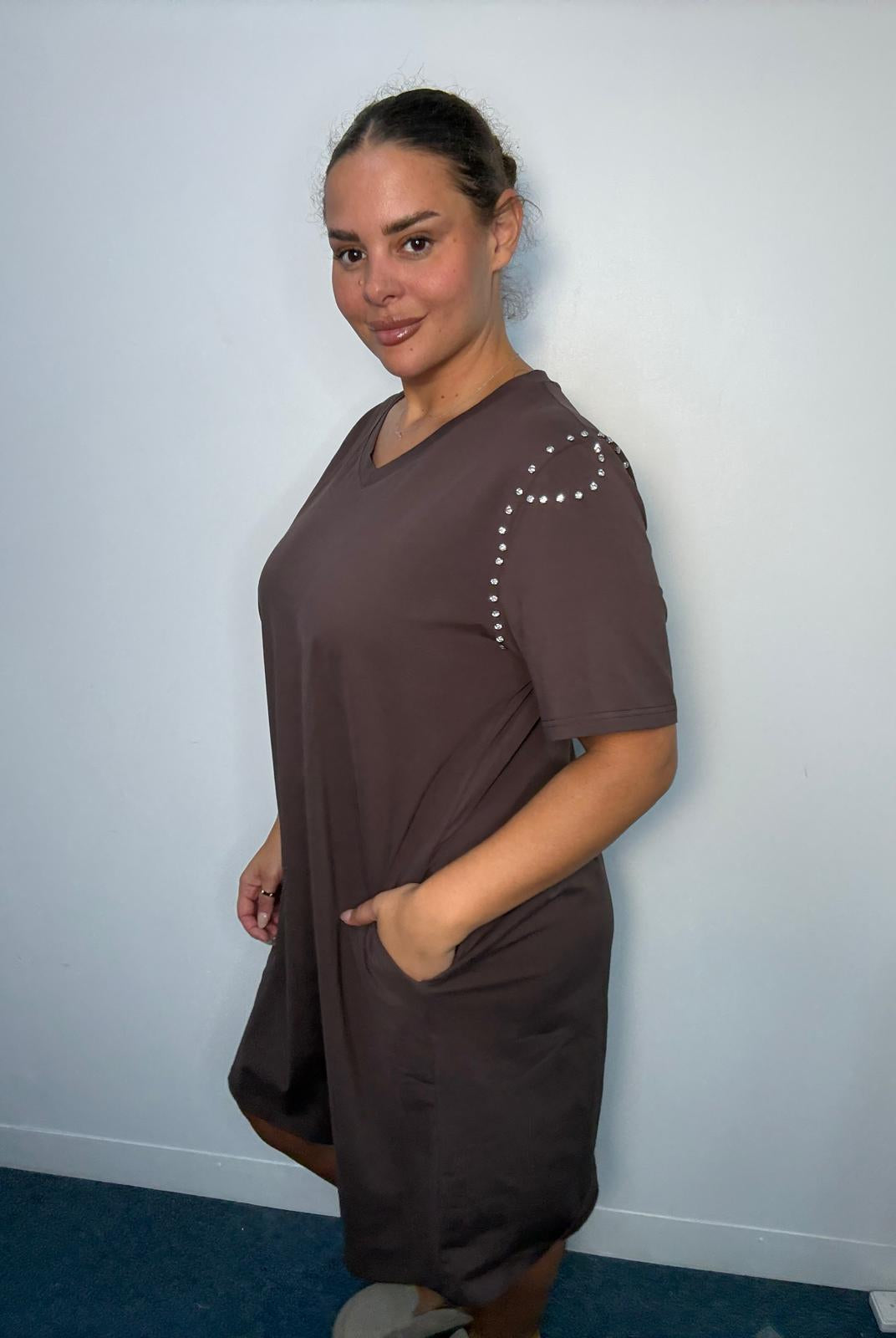 Side view of a chocolate brown plus-size midi dress featuring diamante-style shoulder detailing, short sleeves and side pocket.