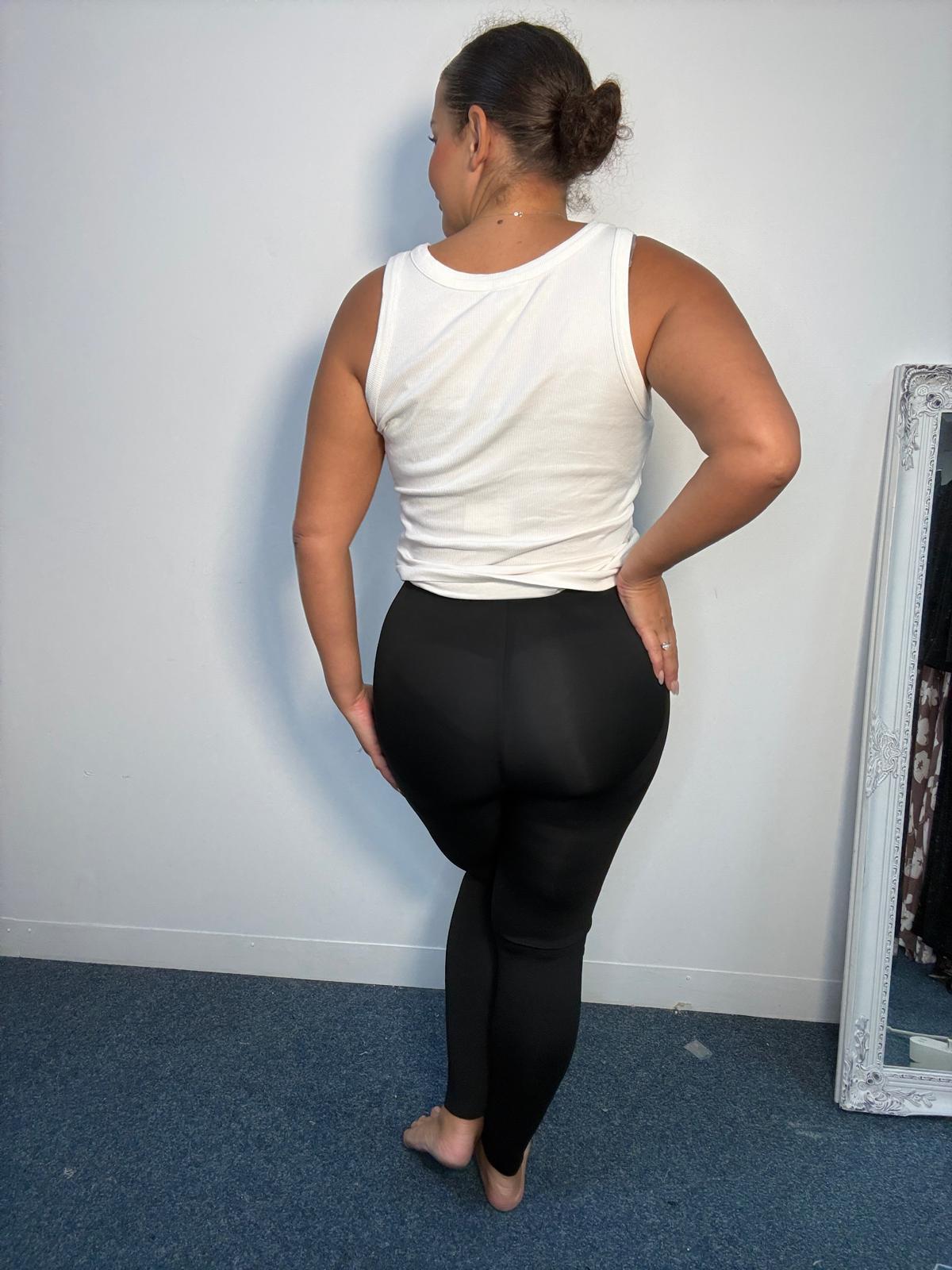 Rear view of plus-size black leggings featuring a high-rise waistband, fitted silhouette and ankle-length finish.