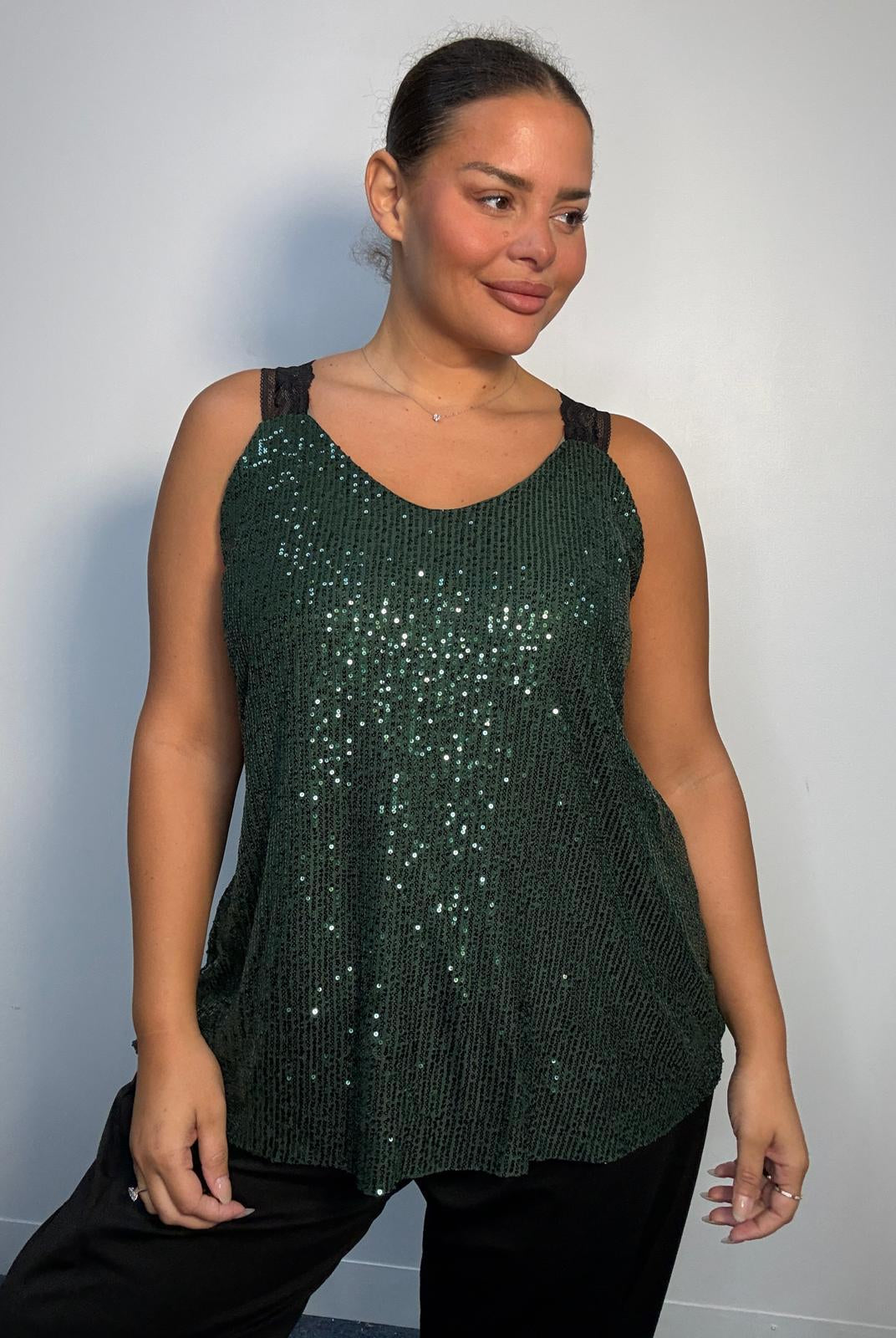 Plus-size model wearing a green sequin cami top with V-neckline, black lace-look shoulder straps and a relaxed flared hem.