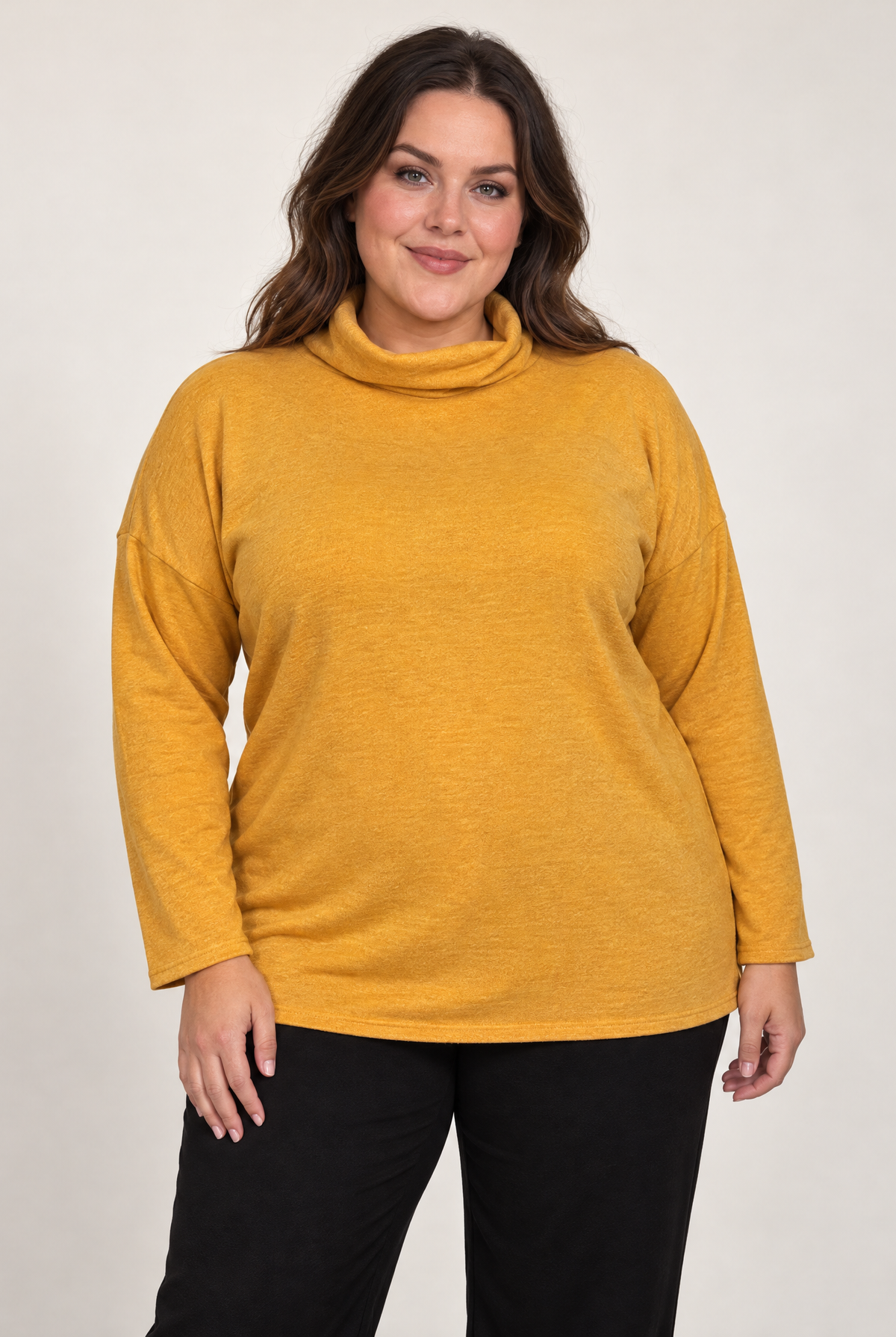Plus-size model wearing a mustard yellow cowl neck long sleeve top with a relaxed fit.