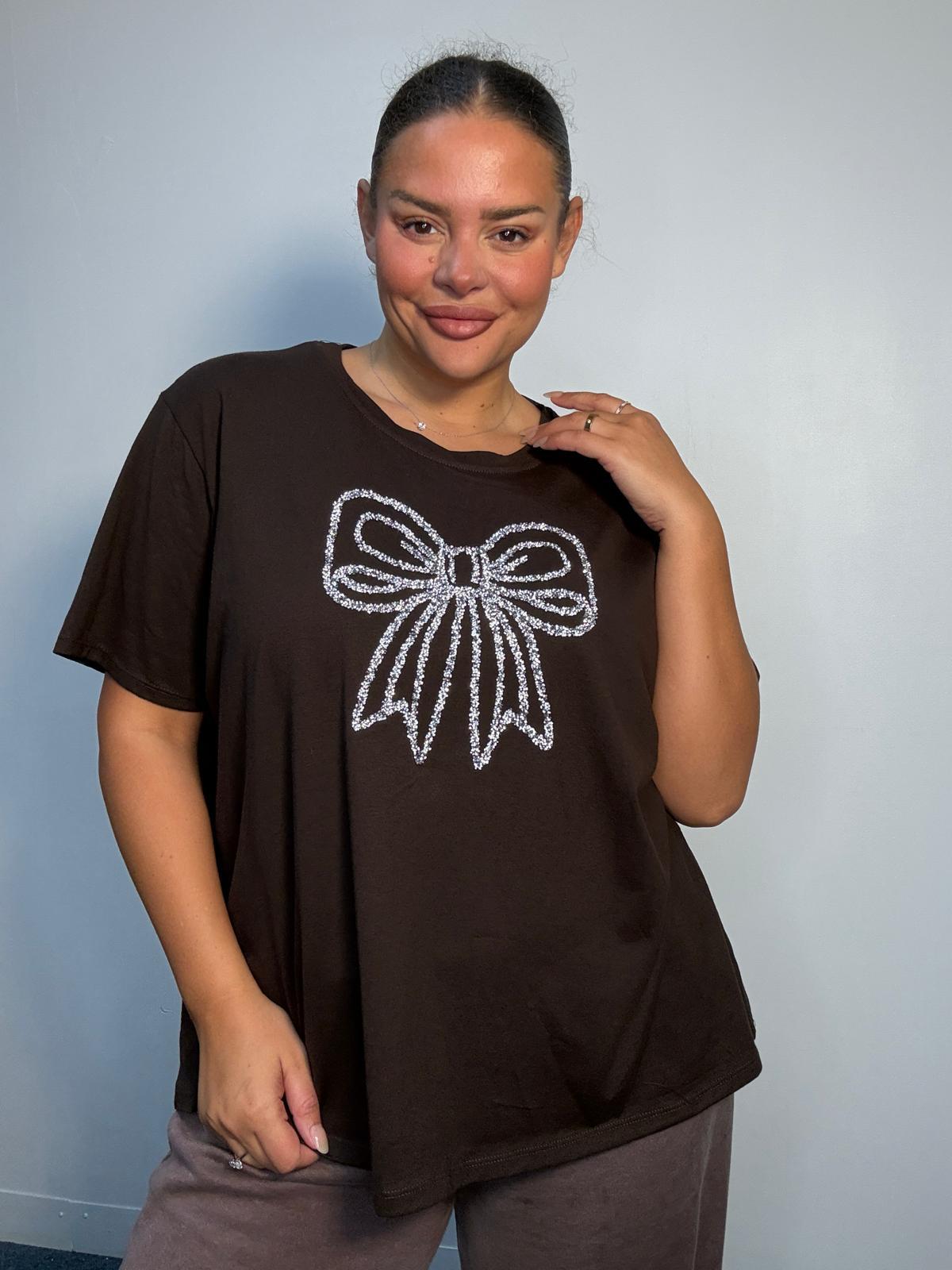 Plus Size Mixed Race Model wearing a brown short sleeve top with bow diamante detail at the front