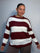 Plus-size model wearing a burgundy and white horizontally striped knitted jumper with round neckline, long sleeves and ribbed trims.