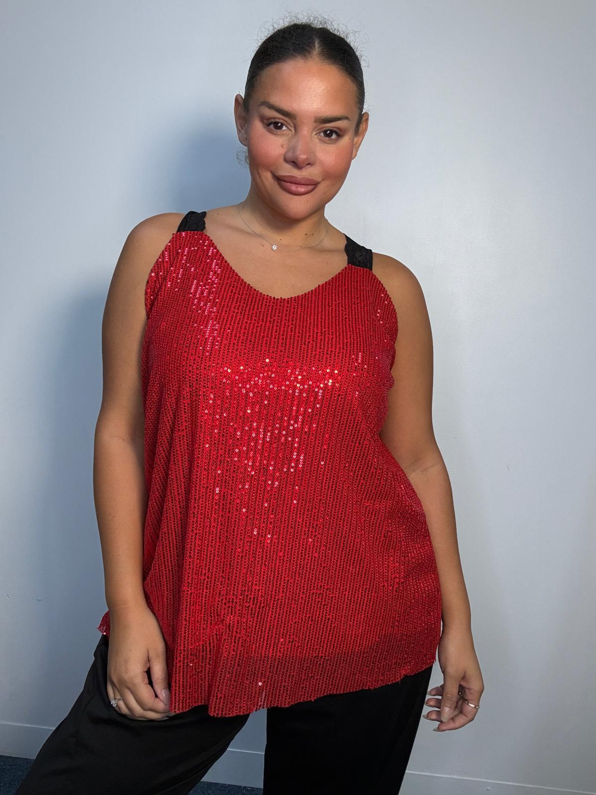 Plus-size model wearing a red sequin cami top with V-neckline, black lace-look shoulder straps and a relaxed flared hem.