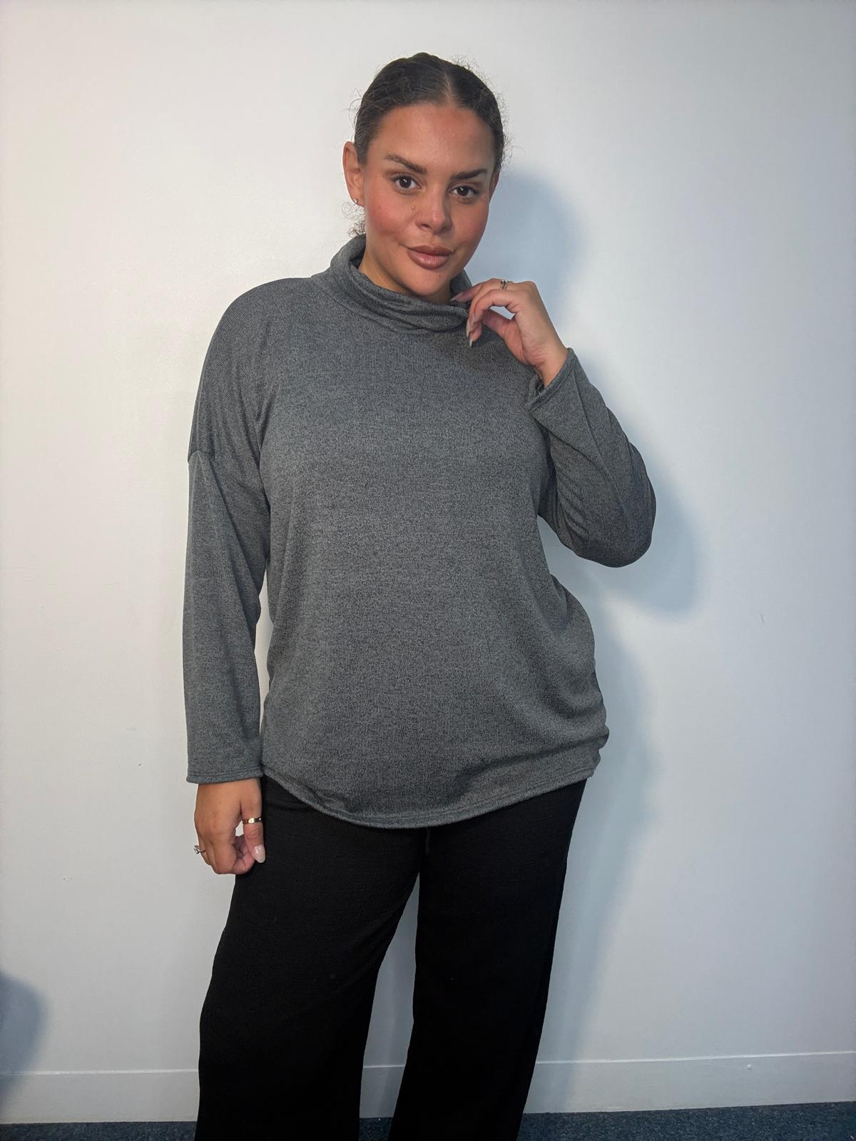 Plus-size model wearing a grey cowl neck long sleeve top with a relaxed fit.