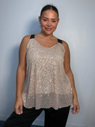 Plus-size model wearing a champagne gold sequin cami top with V-neckline, black lace-look shoulder straps and a relaxed flared hem.