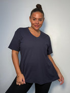 Model wearing a navy plus size V-neck T-shirt with short sleeves and a relaxed fit, styled with black trousers.