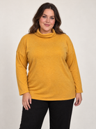 Plus-size model wearing a mustard yellow cowl neck long sleeve top with a relaxed fit.